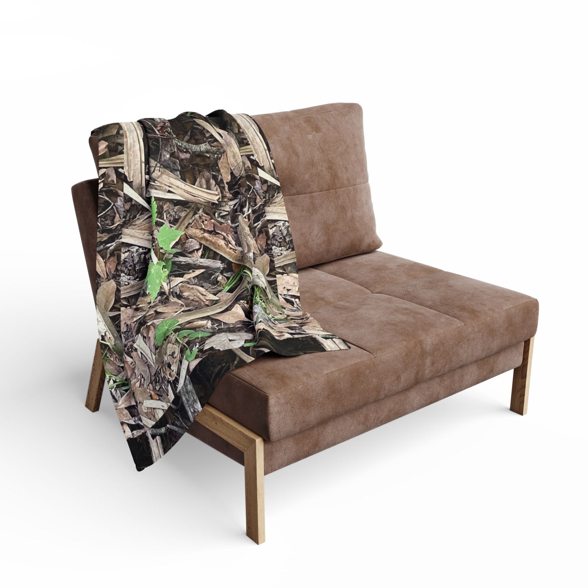 Brown sofa with a camouflage-patterned blanket draped over it on a white background