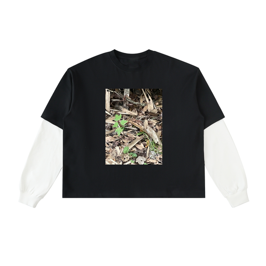 Black t-shirt with a white sleeve featuring a nature-themed graphic on a white background